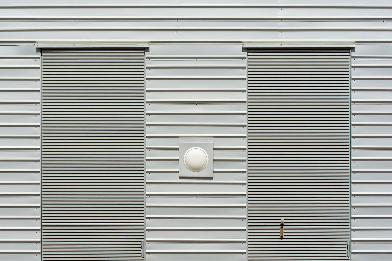 Close-up of a modern industrial building with metal siding and roller doors.