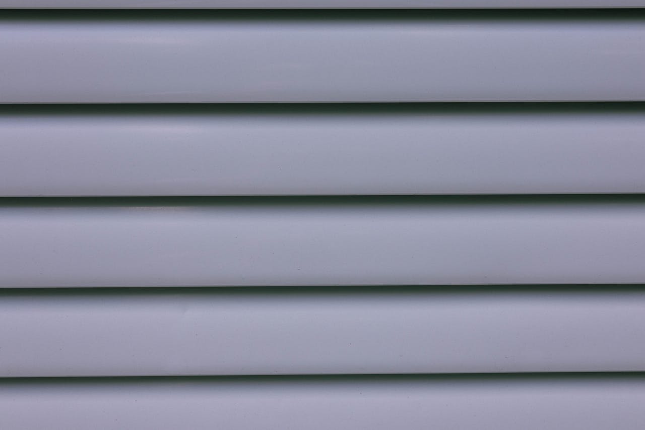 Detailed close-up of gray layered wall paneling showing lines and shadows.