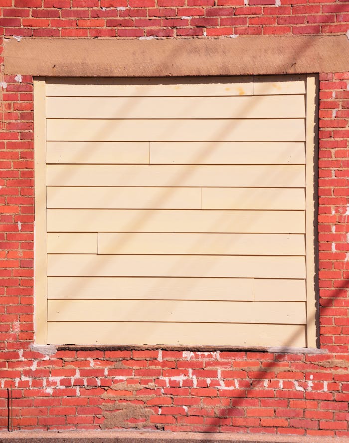 A vintage brick wall with a sealed window in Jacksonville, Texas, captured on a sunny day.